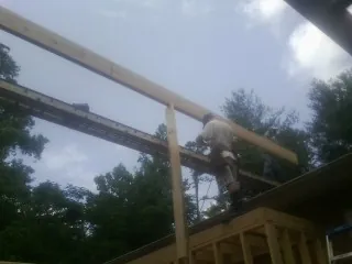 Carpenter setting a ridge beam over a new addition frame — Ice Dam Removal by Roofing Brothers in Bradley Beach