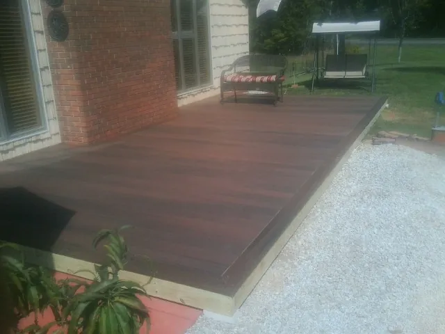 Freshly stained wood deck built against a brick home in Bradley Beach