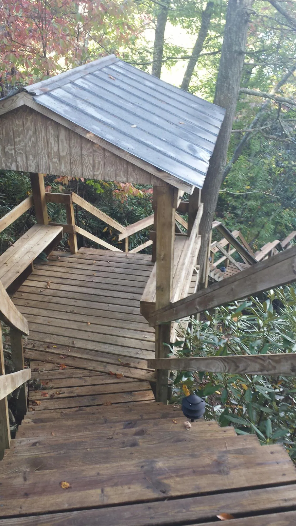 Metal roofed shelter over wooden steps on a wooded walkway — Skylight Repair & Installation work by our crew in Bradley Beach
